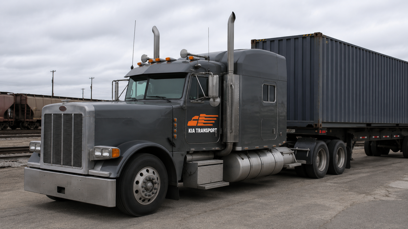 KIA Transport gray Peterbilt truck at CN rail yard